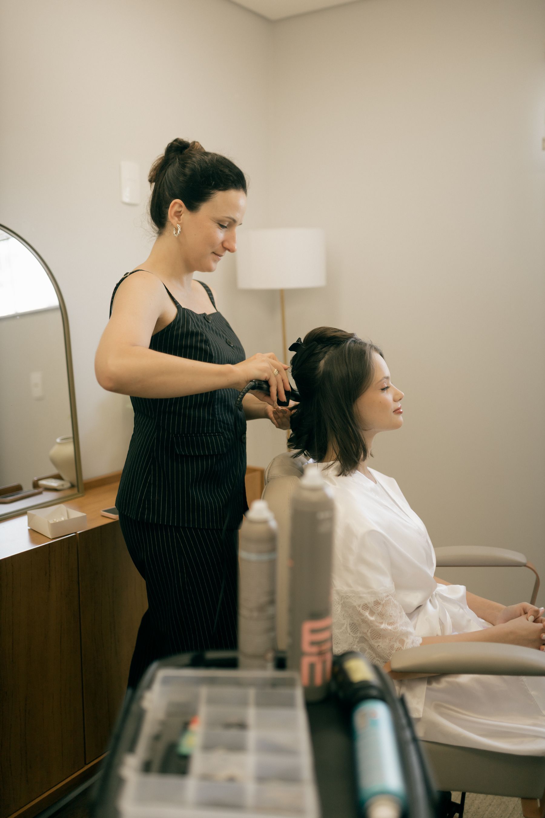Hair stylist carefully styling a client's dark hair