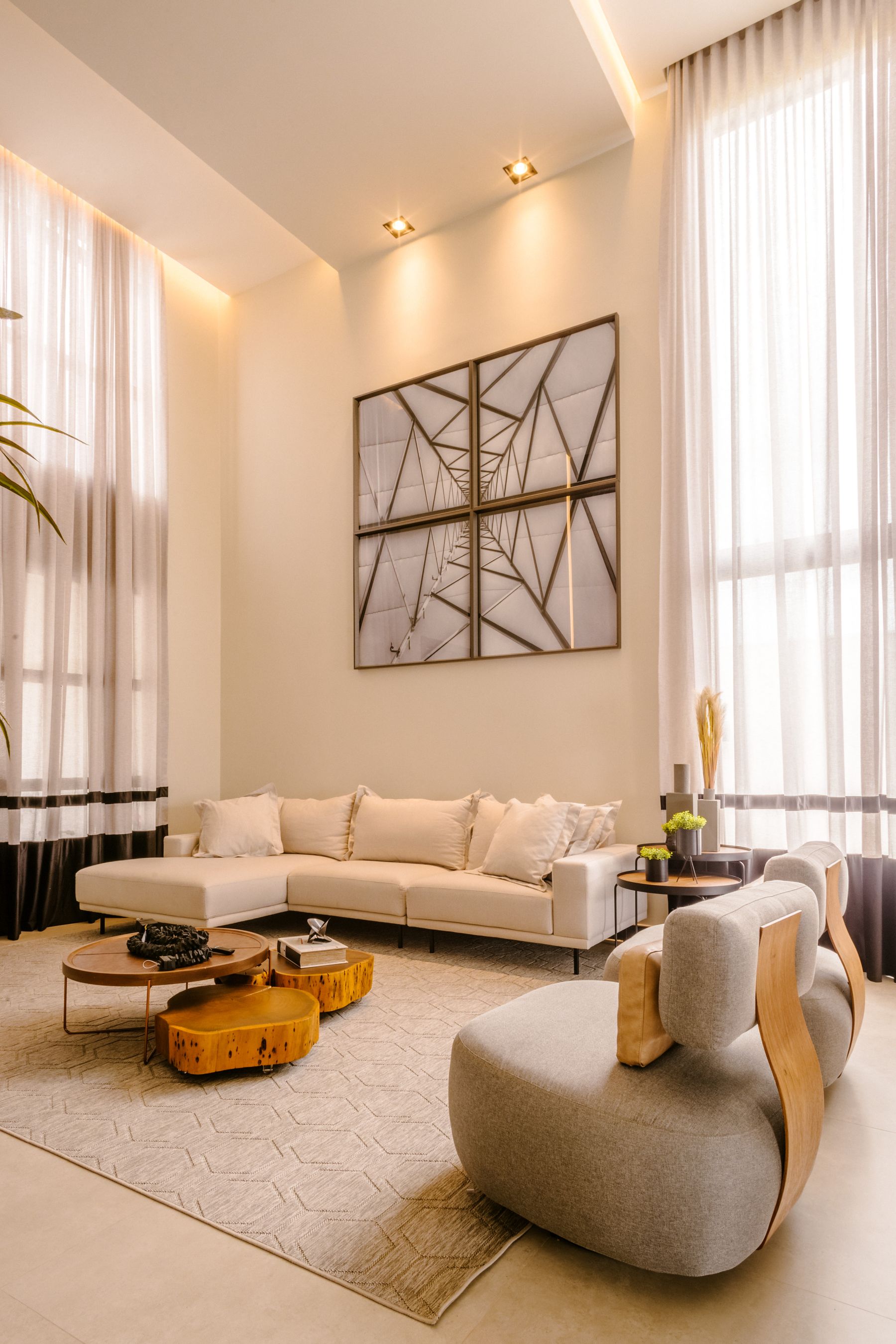 Warm modern living room with tall windows and neutral furnishings